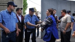 Georgian police grapple with workers as they seize dishes at a satellite TV outlet on June 1. 