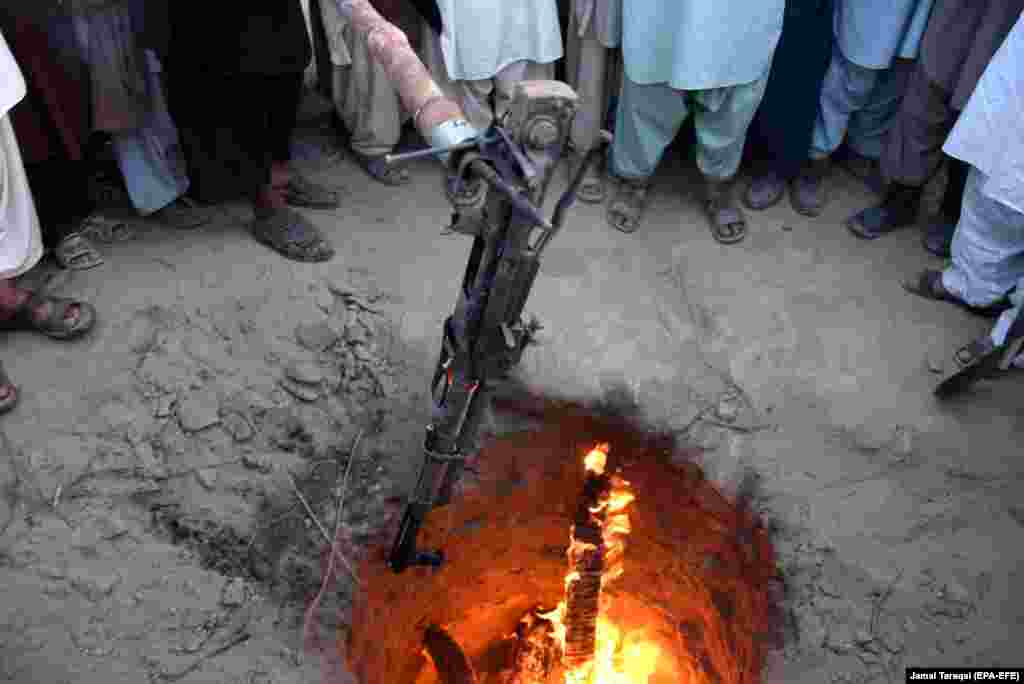 Автомат Калашникова бросают в костер. Этот жест призван символизировать конец вражды между племенами в пакистанской провинции Белуджистан. АК сожгли во время встречи старейшин в округе Кила-Абдулла. (EPA-EFE&nbsp;/&nbsp;Jamal Taraqai)&nbsp;