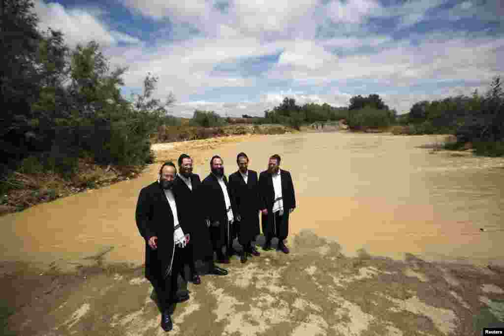 Ultra-Orthodox Jewish men pose for a friend to take their photograph near the flooded Besor stream in Israel&#39;s southern Negev desert near Kibbutz Zeelim on May 8. This week, Israel was hit by unseasonal heavy rain. (Reuters/Amir Cohen)