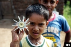 Индийский мальчик в Кашмире показывает осколок минометной мины, предположительно прилетевшей из Пакистана. Август 2015 года
