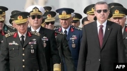 Chief of Staff General Isik Kosaner (left) stands next to Prime Minister Recep Tayyip Erdogan at a wreath-laying ceremony with members of the Supreme Military Council in Ankara last year.