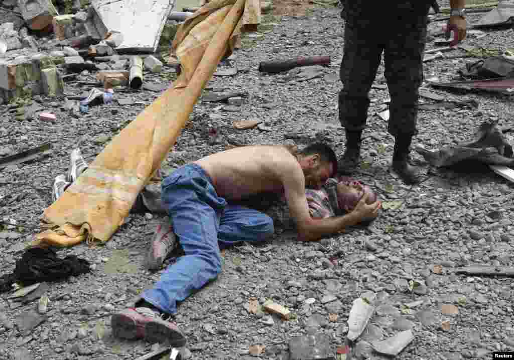 Житель Гори плачет над телом своего родственника, погибшего при бомбардировке Гори, 9 августа 2008 года