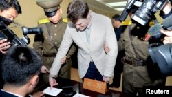 Солтүстік Корея сотына кірер кезде саусағын сканерден өткізіп жатқан АҚШ студенті Отто Уормбир 
