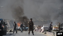 An Afghan security force member stands at the site of a car bomb attack in Kabul on May 31.