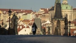 Женщина в маске на опустевшем мосту в Праге, столице Чешской Республики.