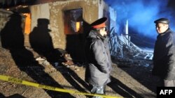 Беш-Кунгей ауылында күдікті топқа қарсы арнайы операция өткен үйдің жанында тұрғандар. 5 қаңтар 2011 жыл.