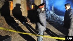 Kyrgyzstan -- Police investigators stand in front of a destroyed house in the village of Arashan, outside Bishkek, 05Jan2011