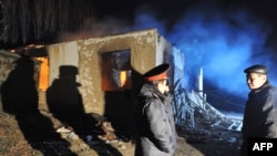 Қырғызстандық тергеушілер Арашан ауылында қарулы бүлікшілердің көзі жойылған үйдің алдында тұр. 5 қаңтар 2011 ж.