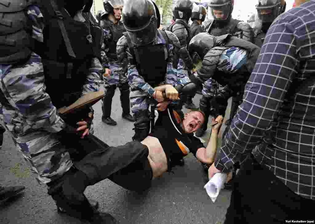 Russian police officers detain a participant at an opposition rally on Tverskaya Street in central Moscow on June 12. Opposition leader and anticorruption blogger Aleksei Navalny called on his supporters to hold a protest on Tverskaya Street, which leads to the Kremlin, instead of the site authorized by Moscow officials. Navalny was sentenced to 30 days in jail and 1,150 protesters were detained. (epa/Yuri Kochetkov)