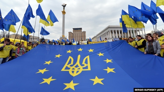 Молодь тримає прапор Євросоюзу з гербом України на майдані Незалежності в Києві, 30 жовтня 2013 року