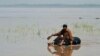A Pakistani resident sits on a innertube in a flooded area following heavy rain on the outskirts of Peshawar on April 4.
