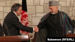 U.S. Defense Secretary Leon Panetta (left) shakes hands with Afghanistan President Hamid Karzai in Kabul on December 13.