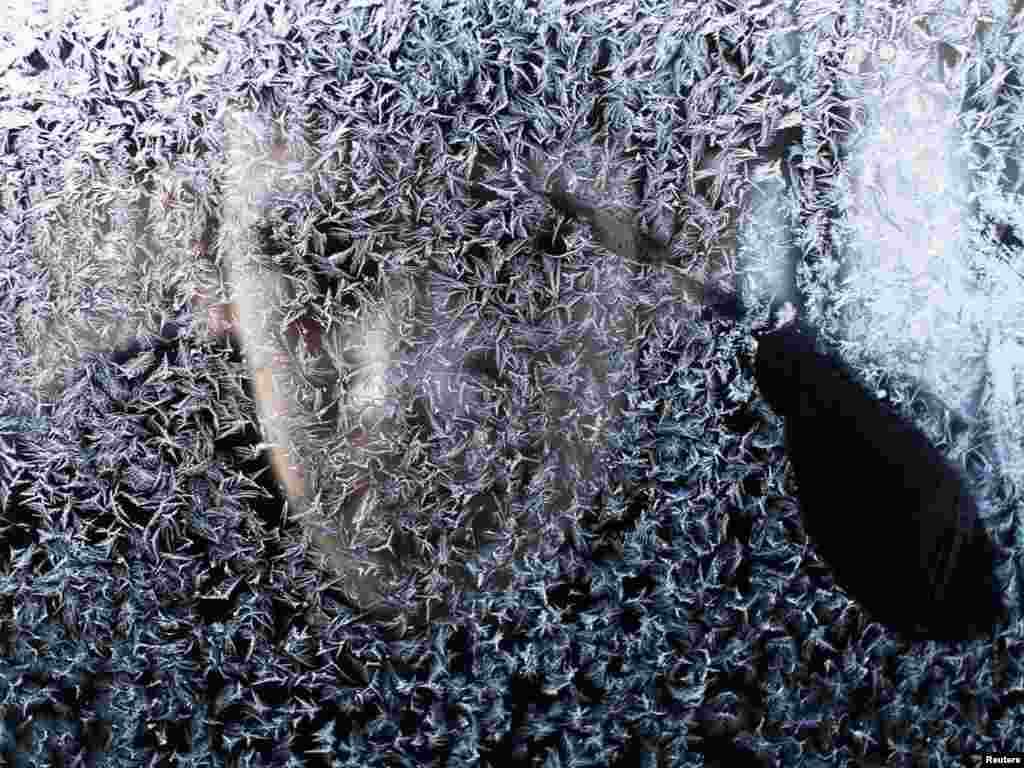 A boy looks through an ice-covered car window in the town of Lipljane near Pristina, Kosovo, on January 2. Photo by Hazir Reka for Reuters