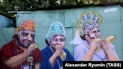 Мурал уличного художника Алекса Мелентьева, изображающий трех болельщиков России, жующих хот-доги на матче Испания-Россия. Москва, 3 июля 2018 года