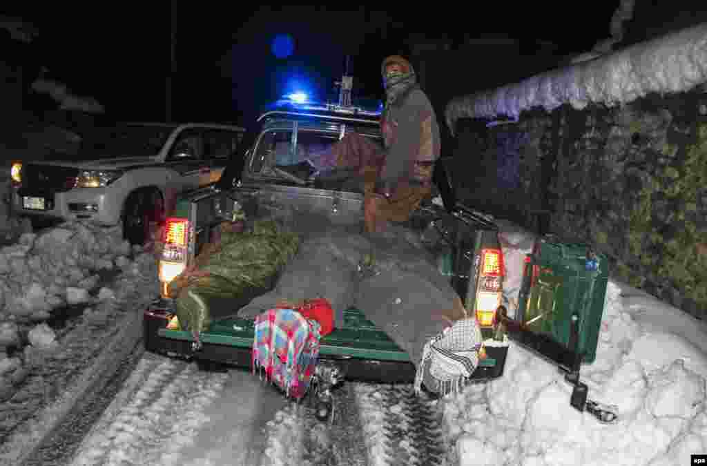 Afghan police remove bodies recovered from the site of an avalanche.
