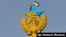 ​Звезда высотки на Котельнической набережной в Москве, раскрашенная в цвета украинского флага.