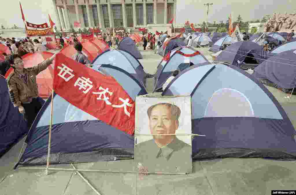 Demonstrators camp out in tents during the mass protest movement and decorate the new tents in a Tiananmen Square camp with a banner and Mao portrait, Monday, May 29, 1989, Beijing, China. The tents were donated by a Hong Kong university. (AP Photo/Jeff Widener)