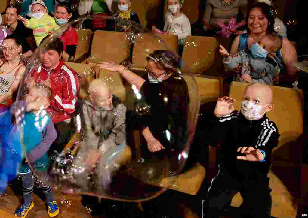 Children and their parents watch a New Year's performance at a children's hematological and oncological center in Minsk. (AFP/Maxim Malinovsky)