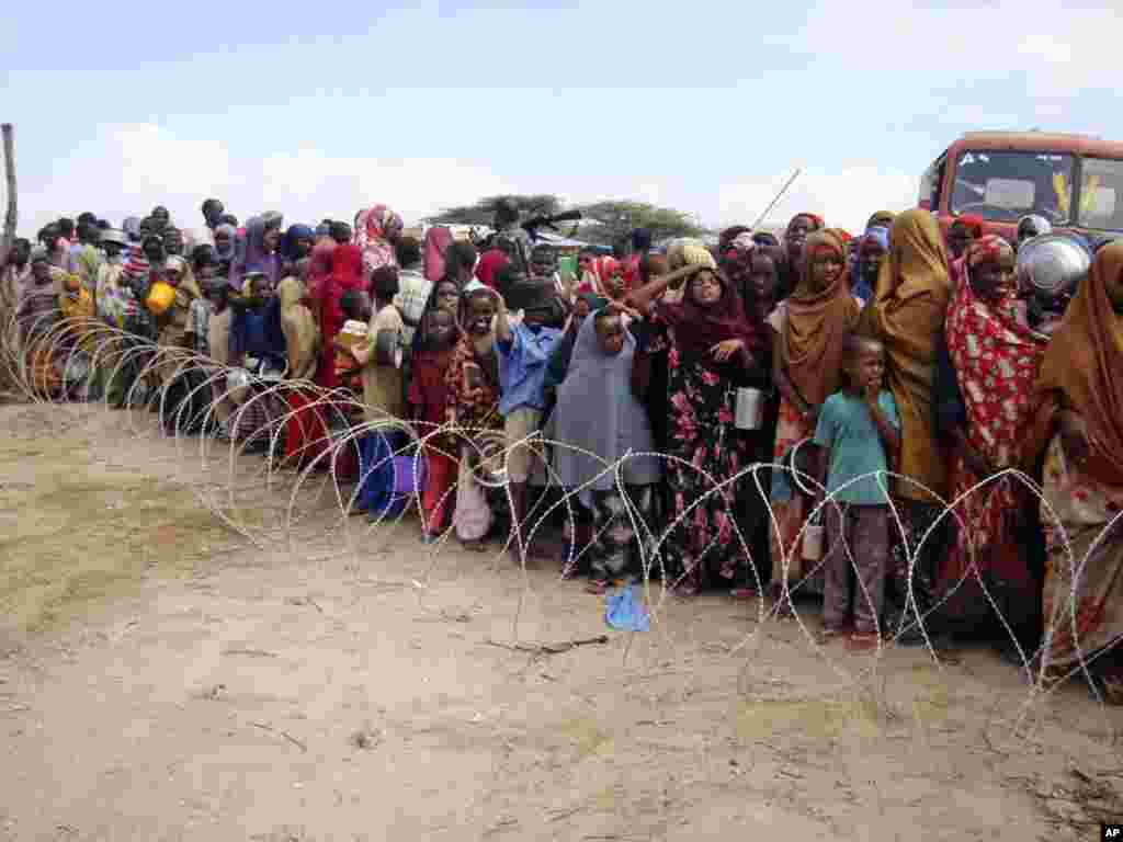 People from southern Somalia stand behind barbed wire in a line to receive aid at a refugee camp in Mogadishu, Somalia, on July 16. More than 10 million people are now affected in drought-stricken areas of Djibouti, Ethiopia, Kenya, Somalia, and Uganda, and the situation was said to be deteriorating. Photo by Farah Abdi Warsameh for AP