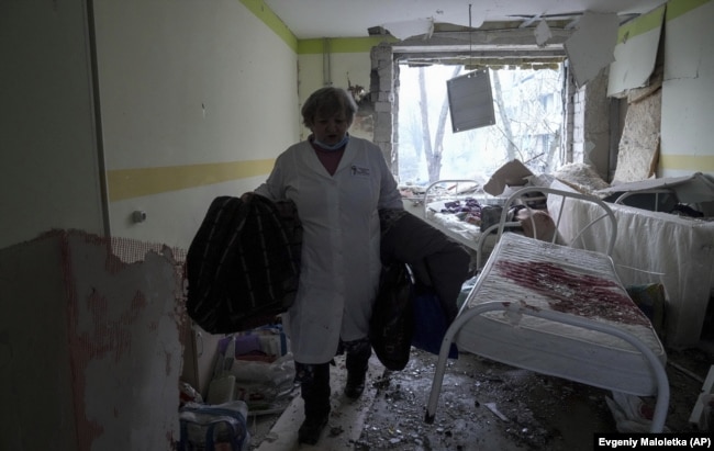 Un operatore sanitario entra nell'ospedale danneggiato il 9 marzo 2022.