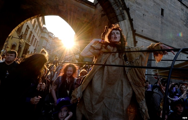 Жінка в костюмі відьми бере участь у параді під час святкування Вальпургієвої ночі в центральній Празі, Чеська Республіка, наприкінці дня 30 квітня 2014 року
