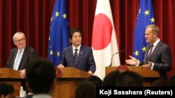 Președintele CE, Donald Tusk, cu premierul japonez Shinzo Abe, și cu președintele Comisiei Europene, Jean-Claude Juncker, la o conferință de presă pe tema Acordului de Liber Schimb între UE și Japonia
