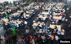 Беженцы обедают в столовой в Мюнхене, сооруженной для них местными властями