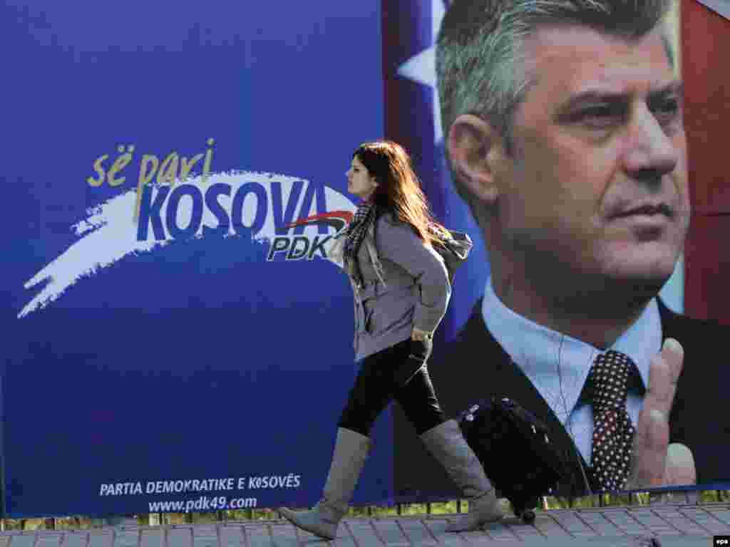 Kosovo -- A woman walks in past an election poster showing Prime Minister and chairman of Democratic Party of Kosovo (PDK) Hashim Thaci in Pristina, 06Dec2010 - epa02483093 A woman walks in front of an election poster showing Kosovo's Prime Minister and chairman of Democratic Party of Kosovo (PDK) Hashim Thaci in the town of Pristina, Kosovo, on 06 December 2010. About 1.6 million voters are eligible to vote for the 1,265 candidates from 29 parties and independent lists running for the 120 seats in Kosovo's parliament, 20 of which are reserved for Serbs and other minorities. The elections will be the first since Kosovo declared independence from Serbia in February 2008. EPA/VALDRIN XHEMAJ 10POTW49 10poty