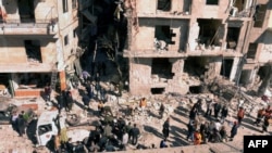 Syria -- Investigators inspecting the blast scene outside a damaged building following a car bomb in the northern city of Aleppo, 18Mar2012