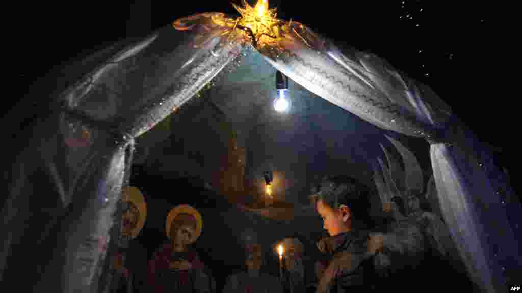 A boy holds a candle during an Orthodox Christmas service in a church in Bishkek, Kyrgyzstan. AFP PHOTO/VYACHESLAV OSELEDKO