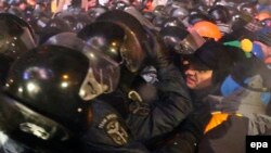 Udar party leader Vitali Klitschko (R) and other antigovernment protesters defend a barricade at Independence Square.