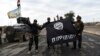 Iraqi soldiers pose with an Islamic State group flag as they hold a position in the village of Gogjali, a few hundred meters from Mosul's eastern edge on November 2.