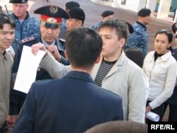 Полицейлер ортасында ҰҚК қызметкерлеріне қарсы хатын көрсетіп тұрған Жанболат Мамай. Астана, 9 қыркүйек 2009 жыл.