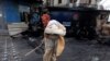 On November 28, a man walks past a police prison van destroyed during clashes between police and protesters a day after the Tehreek-e-Labaik Pakistan Islamist political party called off nationwide protests in Islamabad.