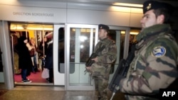 Soldiers stand guard in the Toulouse subway one day after the shooting.