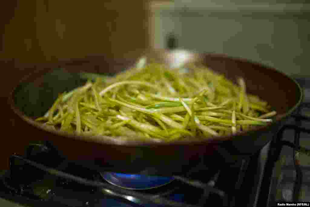 Cleaned, the wild garlic is cooked on a pan over fire.