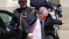 RUSSIA – Russian President Vladimir Putin puts on his jacket as he arrives for the official lunch at Benouville castle, in Normandy, France, June 6, 2014