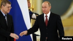 Президент России Владимир Путин (справа) приветствует генерального прокурора Юрия Чайку в Кремле. Москва, 31 января 2013 года.