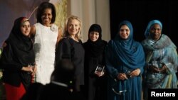 Secretarul de stat Hillary Clinton (a treia din stânga) şi prima doamnă Michelle Obama (a doua din stânga) cu patru dintre cele 10 femei premiate de Departamentul de Stat, 8 martie 2012