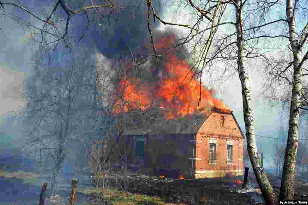 A house burns in the village of Stara Markivka, Poliske district, that was inhabited by squatters, in the exclusion zone on April 9.&nbsp;​Many abandoned villages burnt down&nbsp; in the area.