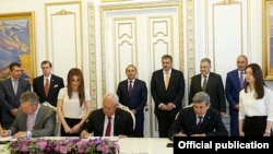 Armenia - Energy Minister Yervand Zakharian (C) and Joseph Brandt (L), the CEO of the U.S company ContourGlobal, sign a deal on the sale of Vorotan Hydro Cascade, Yerevan, 8Jun2015.