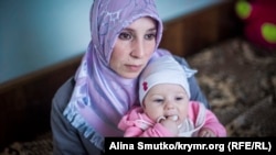 Алиме Абдуллаева держит на руках дочь Асму