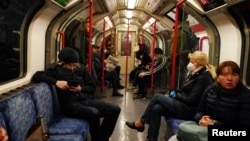 Коронавирус пандемиясы кезінде Лондон метросында көлікте отырған адамдар. Ұлыбритания, 13 мамыр 2020 жыл.