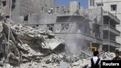 Civilians and members of the Free Syrian Army inspect a damaged building in Aleppo after a morning air strike by Syrian war planes on September 19.