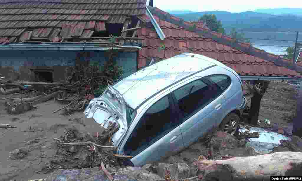 A car is half-buried in mud in the village of Tekija, near the town of Kladovo, in eastern Serbia. 