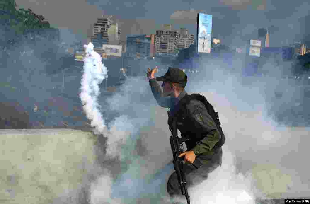 Член Боліварської національної гвардії, який підтримує лідера опозиції Хуана Гуайдо, кидає балончик зі сльозогінним газом під час протистояння з військовими, вірними урядові президента Ніколаса Мадуро