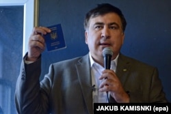 Михаил Саакашвили показывает журналистам свой краинский паспорт. Варшава, 6 августа