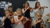 Діти у літньому таборі вчаться музичним інструментам