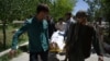 Afghan volunteers bring the body of a resident killed in a car-bomb attack to the Wazir Akbar Khan hospital in Kabul on May 31.