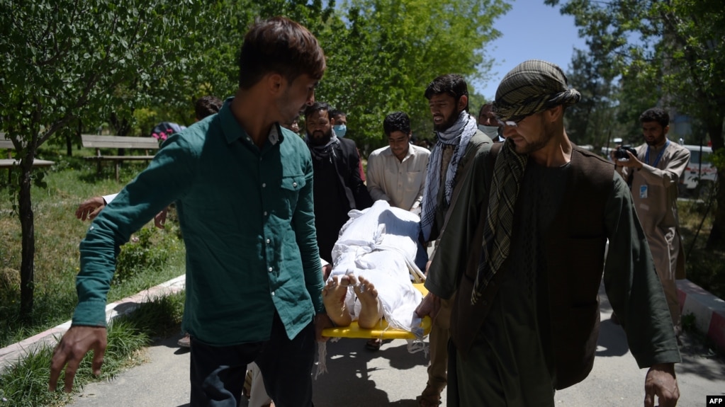 Afghan volunteers bring the body of a resident killed in a car-bomb attack to the Wazir Akbar Khan hospital in Kabul on May 31.